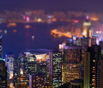 40108928 - night aerial view panorama of hong kong skyline and victoria harbor. tilt shift effect. abstract futuristic cityscape with modern skyscrapers